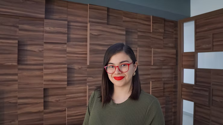 Fotografía de Cyndi Soto sonriendo con lentes rojos